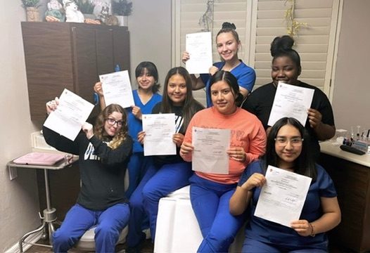Premier Dental Academy graduates holding their certificates in Longview